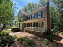 Well-maintained two-story home with charming front porch, complemented by established landscaping and mature trees at 1501 Ramson Ct, Raleigh, NC 27603