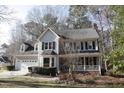 Traditional two-story home featuring an attached garage, front porch, and mature trees in a landscaped yard at 1501 Ramson Ct, Raleigh, NC 27603