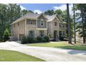 Spacious home with brick and stone details, a long driveway, and lush green landscaping at 156 Stoney Creek Way, Chapel Hill, NC 27517