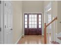 A bright foyer showcasing a wooden front door with sidelights and hardwood floors at 1612 Grappenhall Dr, Apex, NC 27502
