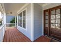 The covered front porch featuring wood decking, decorative columns and a beautiful wood front door at 1612 Grappenhall Dr, Apex, NC 27502