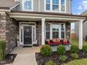 Inviting front porch with stone pillars, comfortable seating, and lush landscaping at 190 Hickory Run Ln, Franklinton, NC 27525