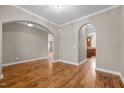 Spacious living room with hardwood floors, arched doorways, and neutral paint at 1938 Glenkirk Dr, Burlington, NC 27215