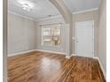 Bright living room with beautiful hardwood floors, a window, and a white door at 1938 Glenkirk Dr, Burlington, NC 27215
