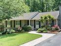 Charming exterior with brick walkway, lush landscaping, and inviting facade on a sunny day at 2001 Manuel St, Raleigh, NC 27612