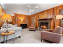 Cozy living room with wood paneled walls, brick fireplace, and comfortable seating at 203 Lexington Rd, Chapel Hill, NC 27516
