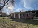 Well-maintained brick ranch with mature trees and front porch at 2117 George Winston Rd, Oxford, NC 27565