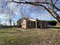 Charming brick home featuring a covered front porch and well-manicured lawn at 2117 George Winston Rd, Oxford, NC 27565