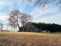 Brick ranch home with a covered parking area on a large grassy lot at 2117 George Winston Rd, Oxford, NC 27565