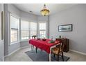 Dining area with bay windows, stylish chandelier and a red table cloth at 2152 Haig Point Way, Raleigh, NC 27604