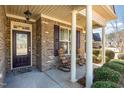 Covered front porch with classic brickwork, rocking chairs, and decorative plants, ideal for relaxation at 231 Easy Wind Ln, Garner, NC 27529