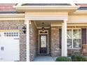 Inviting front porch with brick columns, rocking chairs, and decorative lighting enhances the home's curb appeal at 231 Easy Wind Ln, Garner, NC 27529
