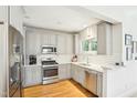 Bright kitchen boasts stainless steel appliances, white subway tile, and grey cabinetry at 2431 Winburn Ave, Durham, NC 27704