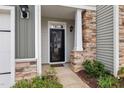 Inviting entryway with a black front door, stone accents, and lush greenery, offering curb appeal and charm at 2451 Memory Ridge Dr, Raleigh, NC 27606