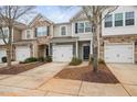 Charming townhomes showcasing a mix of stone and siding, each with a one car garage and well-manicured landscaping at 2451 Memory Ridge Dr, Raleigh, NC 27606