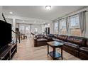 Cozy living room with large windows, hardwood floors, and comfortable leather sofa at 3015 Cypress Lagoon Ct, Durham, NC 27703