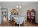 Cozy dining room with hardwood floors, stylish chandelier, and elegant decor and a cabinet at 3116 Kensington Pl, Burlington, NC 27215