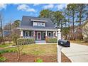 Inviting blue home boasting a classic design with a well-manicured lawn and charming curb appeal at 332 Pine Nut Ln, Apex, NC 27502