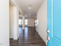 Inviting entryway with a light blue front door and pristine hardwood floors and white walls at 3354 Brunot St, New Hill, NC 27562