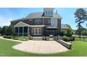 Gorgeous outdoor space featuring a stone patio, built-in grill, gazebo, screened porch, and lush garden at 3732 Sparrow Pond Ln, Raleigh, NC 27606