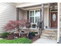 Inviting front porch with stone accents, comfortable seating, and attractive landscaping at 4014 Peeler Ct, Rolesville, NC 27571