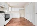 Well-lit kitchen equipped with white cabinets and modern appliances on a hardwood floor at 432 Fowlkes St, Wendell, NC 27591