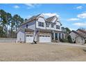 Exterior of a two story house featuring a basketball hoop, stone garage and white siding at 4913 Sunset Stream Dr, Fuquay Varina, NC 27526