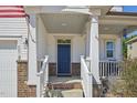 Close-up showcasing the inviting front porch with brick accents and a classic blue entry door at 505 Ferry Ct, Wake Forest, NC 27587