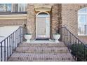 Charming home front entrance with brick steps, iron railings, and decorative potted plants at 508 Spencer Crest Ct, Cary, NC 27513