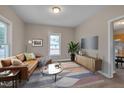 Cozy living room featuring hardwood floors, stylish furniture, and plenty of natural light at 516 Craven Road, Durham, NC 27704