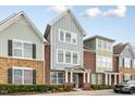 Charming townhouses with brick and siding exteriors, manicured landscaping, and covered entrances at 627 Balsam Fir Dr, Cary, NC 27519
