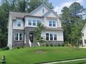 Charming two-story home with stone accents, white siding, and a lush green lawn at 664 The Parks Dr, Pittsboro, NC 27312