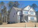 Two-story home with stone accents, multiple windows, and a well-maintained lawn at 664 The Parks Dr, Pittsboro, NC 27312