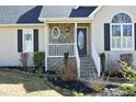 Inviting front porch with stone accents and manicured landscaping at 7127 Lark Ln, Sanford, NC 27332