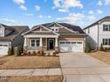 Charming home with a welcoming front porch and solar panels for energy efficiency at 721 Sage Oak Ln, Holly Springs, NC 27540