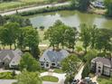 Aerial view of home on lush lot with a view of nearby golf course and lake at 7217 Manor Oaks Dr, Raleigh, NC 27615