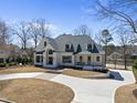 Stunning two-story home with a circular driveway, manicured lawn, and elegant architectural details at 7217 Manor Oaks Dr, Raleigh, NC 27615