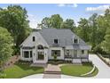 Two-story brick home with manicured landscaping, curved driveway and a welcoming front porch at 7217 Manor Oaks Dr, Raleigh, NC 27615