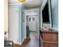 Hallway with blue walls, connecting rooms with a glimpse of the home's interior at 7534 Overhills Rd, Spring Lake, NC 28390