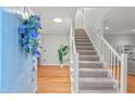 Bright entryway featuring hardwood floors, a staircase, and a decorative floral arrangement at 8 Bryncastle Ct, Durham, NC 27707