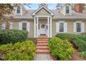Welcoming front entrance with brick steps, complemented by lush green shrubbery and a decorative wreath at 8 Bryncastle Ct, Durham, NC 27707