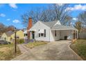 Side exterior view of a cozy home with a brick chimney and covered carport, perfect for outdoor entertaining at 910 Bellvue St, Burlington, NC 27217