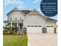 Stunning two-story home featuring a three-car garage, a landscaped yard and a charming front porch at 1001 Peterson Ridge Rd, Fuquay Varina, NC 27526