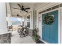 Charming front porch with rocking chairs, ceiling fans, and a welcoming blue front door at 1001 Peterson Ridge Rd, Fuquay Varina, NC 27526