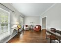 Cozy living room with hardwood floors, neutral walls, and plenty of natural light from large windows at 1007 Surry Dale Ct, Apex, NC 27502