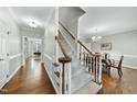 Bright foyer with hardwood floors and carpeted stairs with wooden railings leading upstairs at 1007 Surry Dale Ct, Apex, NC 27502