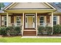 Inviting front porch with a classic brick facade, hanging flower baskets, and rocking chairs at 1056 Lukestone Dr, Fuquay Varina, NC 27526