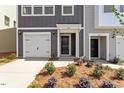 Attractive townhome showcasing a gray and white exterior, private garage, and landscaped front yard at 120 Central Townes Way # 292, Raleigh, NC 27603