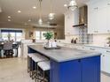 Well-lit kitchen with white cabinets, blue island with barstool seating and modern appliances at 127 Gadwall Ln, Durham, NC 27703