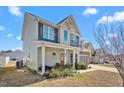 Charming two-story home with covered porch and manicured lawn at 130 Campaign Dr, Mebane, NC 27302